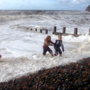 Brothers Dean and Danny Dougherty from Whitehaven  and Loise Gibbs from St Bees are caught by the waves as they run back up the pepples as they play on the beach throwing pepples into the sea at St Bees yesterday (Sun) The sea was coming right up