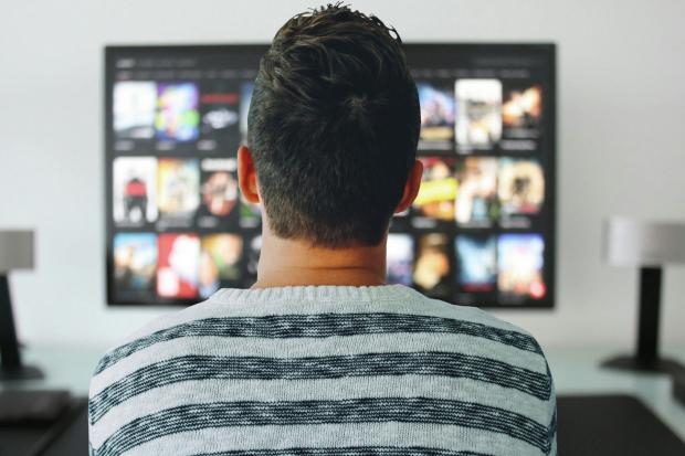 Whitehaven News: A man watching a smart TV. Credit: Canva