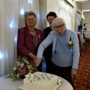CELEBRATE: Joan Mossop cuts the Diamond Anniversary celebration cake