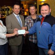 Gary McKee (right) accepts a £1000 cheque from Belinda Taylor proprietor of the Black Beck Inn part of over £20,000 sponsorship they are raising for Macmillan Cancer Care. He, with Robert Currie and Liam O'Neill they treked across New Zealands