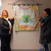 Karen Jones (Left) and June Pearson stand with the tapestry
