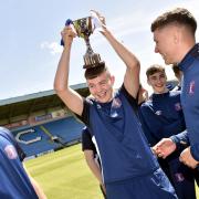 Carlisle United Community Sports Trust Football Development team are presented with their trophy for winning the EFL League Championship trophy at Brunton Park in Carlisle. ..Midfielder James Best has fun with team-mates....MONDAY 10th JUNE 2019. DAVID